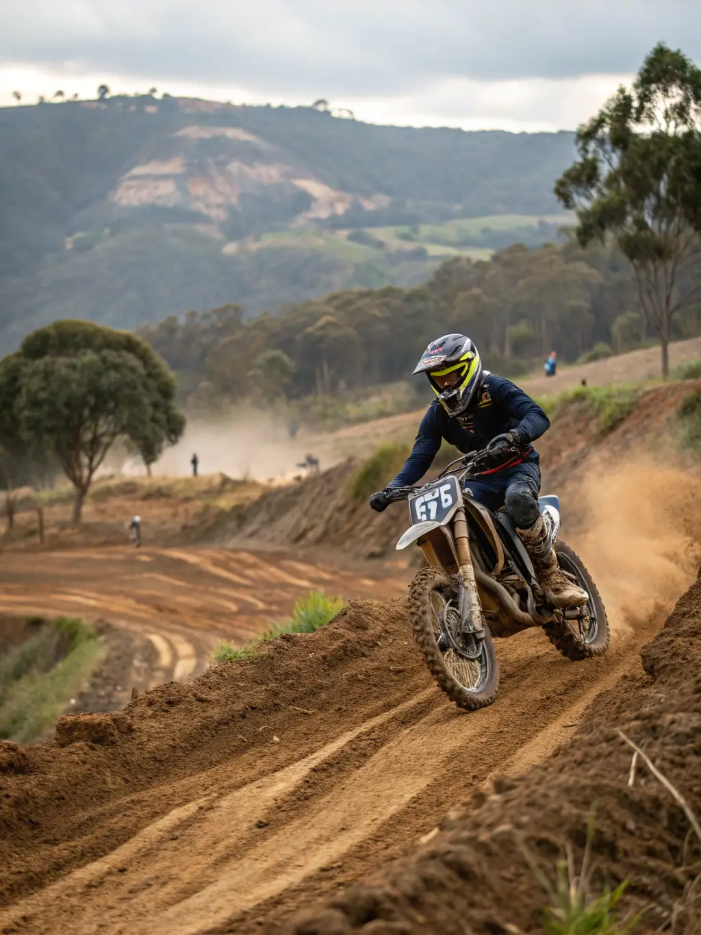 A close-up shot of a young rider's focused expression as they navigate a challenging section of the track, showcasing their determination and skill. The background is blurred to emphasize the rider's concentration.